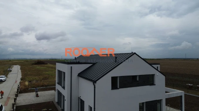 Stavba střechy na novém moderním dvojdomě (pokládka střešních panelů Klik Retro Plus RAL 7016 Mat) ve Slaný